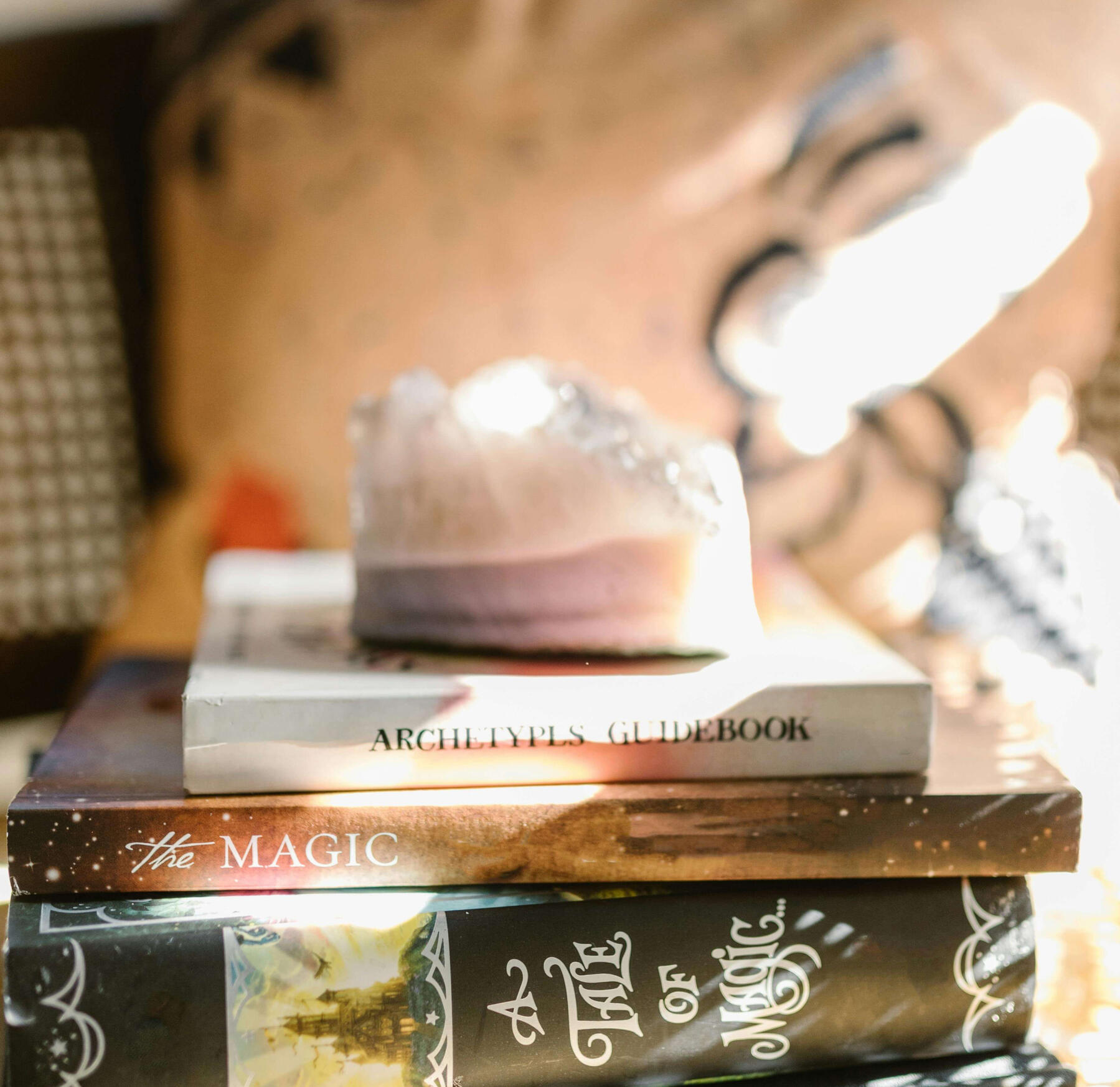Crystal manifestation This is a photo of a crystal sitting on top of some magic books